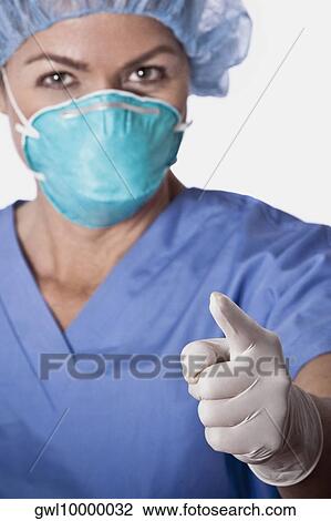 Female surgeon wearing a flu mask and pointing forward View Large Photo Image Stock Image - Female surgeon wearing a flu mask and pointing forward. Fotosearch
