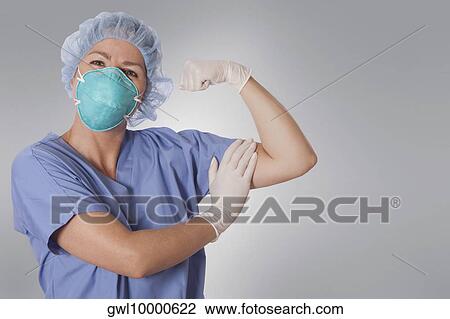 Female surgeon wearing flu mask and showing biceps View Large Photo Image Stock Image - Female surgeon wearing flu mask and showing biceps. Fotosearch