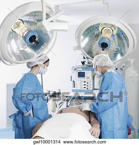Picture - Female surgeons performing surgery. Fotosearch
