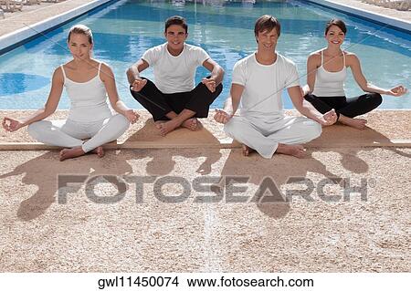 Picture - Four friends practicing yoga at the poolside. Fotosearch
