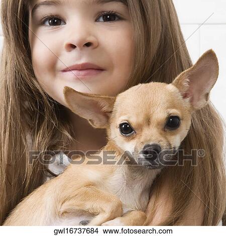 Girl carrying a dog in a veterinary hospital View Large Photo Image Picture - Girl carrying a dog in a veterinary hospital. Fotosearch