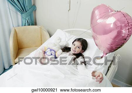 Girl holding a balloon on hospital bed View Large Photo Image Stock Image - Girl holding a balloon on hospital bed. Fotosearch