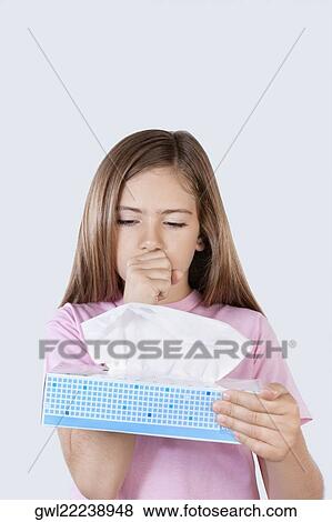 Stock Photo - Girl holding a flu mask box and coughing. Fotosearch