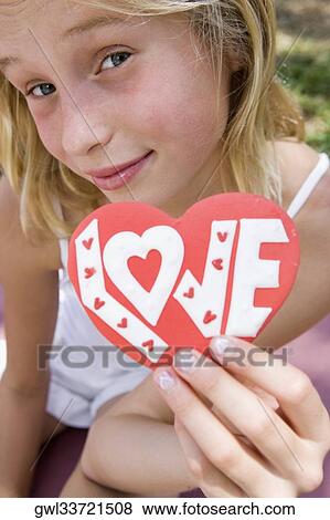 Girl holding a valentine card View Large Photo Image Stock Photo - Girl holding a valentine card. Fotosearch