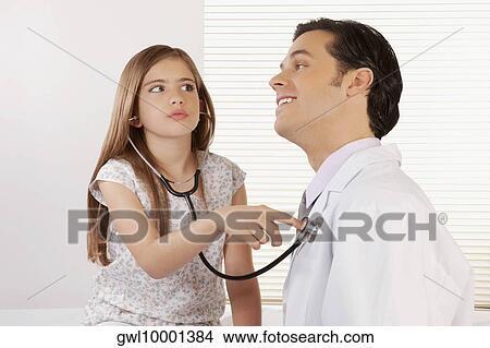 Picture - Girl listening to the heartbeat of a doctor with a stethoscope. Fotosearch