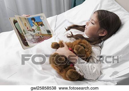 Girl lying in a hospital bed and reading a comic book View Large Photo Image Stock Photo - Girl lying in a hospital bed and reading a comic book. Fotosearch