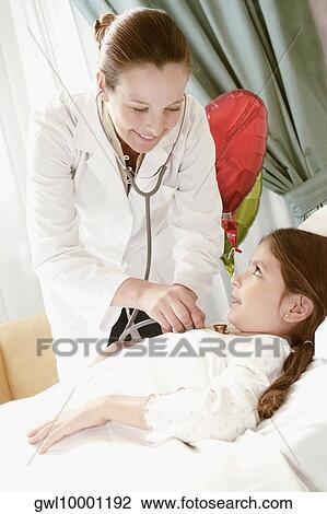 Girl on a hospital bed being examined by a female doctor View Large Photo Image Stock Image - Girl on a hospital bed being examined by a female doctor. Fotosearch