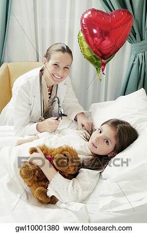 Girl on a hospital bed being examined by a female doctor View Large Photo Image Stock Image - Girl on a hospital bed being examined by a female doctor. Fotosearch