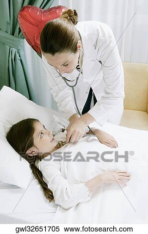 Girl on a hospital bed being examined by a female doctor View Large Photo Image Stock Photography - Girl on a hospital bed being examined by a female doctor. Fotosearch