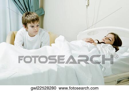 Girl on a hospital bed with her brother sitting beside her View Large Photo Image Stock Image - Girl on a hospital bed with her brother sitting beside her. Fotosearch