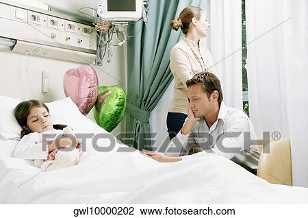 Girl on a hospital bed with her parents beside her View Large Photo Image Stock Image - Girl on a hospital bed with her parents beside her. Fotosearch