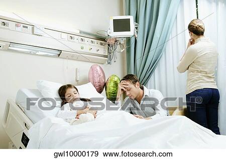 Girl on a hospital bed with her parents beside her View Large Photo Image Stock Photo - Girl on a hospital bed with her parents beside her. Fotosearch