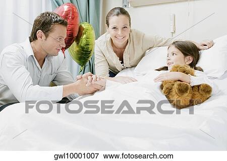 Girl on a hospital bed with her parents beside her View Large Photo Image Stock Photo - Girl on a hospital bed with her parents beside her. Fotosearch