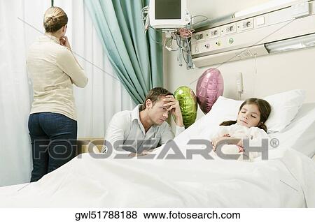 Girl on a hospital bed with her parents beside her View Large Photo Image Stock Photo - Girl on a hospital bed with her parents beside her. Fotosearch