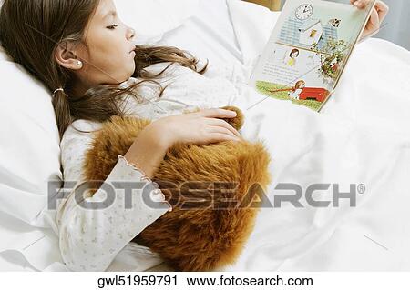 Girl reading a comic book on a hospital bed View Large Photo Image Stock Image - Girl reading a comic book on a hospital bed. Fotosearch