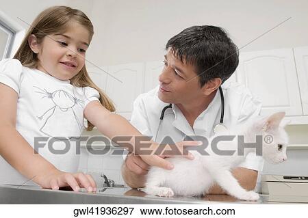 Stock Photo - Girl talking to a vet and stroking a cat. Fotosearch