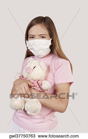 Girl wearing flu mask and holding a stuffed toy View Large Photo Image Stock Image - Girl wearing flu mask and holding a stuffed toy. Fotosearch