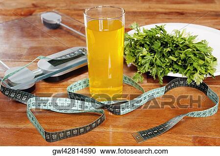 Glass of juice with a weighing scale and a tape measure View Large Photo Image Stock Image - Glass of juice with a weighing scale and a tape measure. Fotosearch