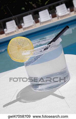 Glass of lemonade at the poolside View Large Photo Image Stock Photo - Glass of lemonade at the poolside. Fotosearch