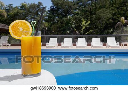 Glass of orange juice at the poolside View Large Photo Image Stock Image - Glass of orange juice at the poolside. Fotosearch