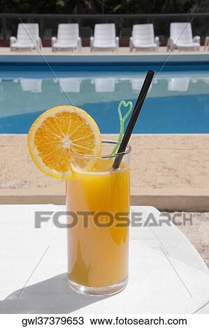 Glass of orange juice at the poolside View Large Photo Image Stock Image - Glass of orange juice at the poolside. Fotosearch