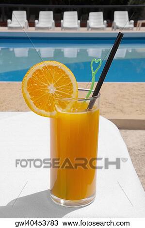 Glass of orange juice at the poolside View Large Photo Image Stock Image - Glass of orange juice at the poolside. Fotosearch