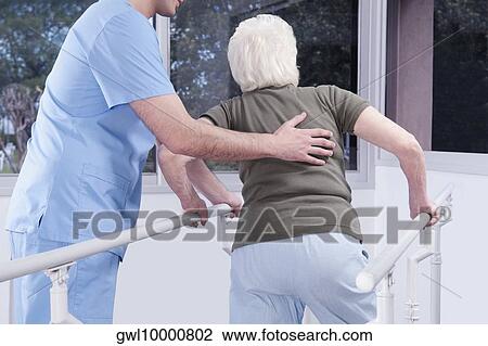 Health worker assisting a disabled woman in walking View Large Photo Image Stock Image - Health worker assisting a disabled woman in walking. Fotosearch