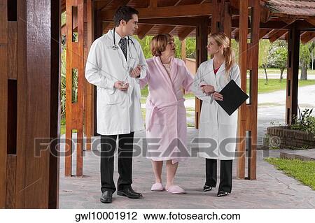 Stock Image - Health worker assisting a woman and a man. Fotosearch