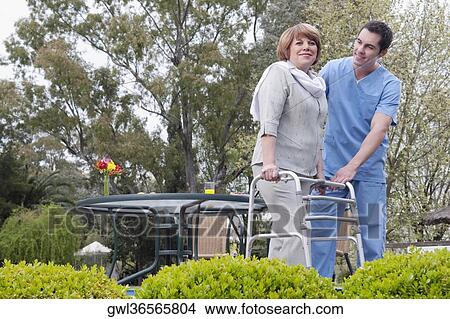 Healthcare worker assisting a patient in walking in a rehabilitation centre View Large Photo Image Picture - Healthcare worker assisting a patient in walking in a rehabilitation centre. Fotosearch