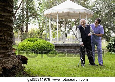 Healthcare worker assisting a patient in walking View Large Photo Image Stock Photo - Healthcare worker assisting a patient in walking. Fotosearch