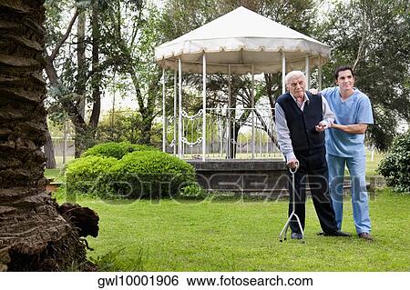 Healthcare worker assisting a patient in walking View Large Photo Image Stock Photograph - Healthcare worker assisting a patient in walking. Fotosearch