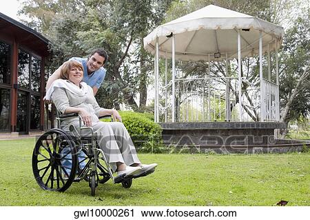 Healthcare worker pushing a woman sitting in a wheelchair View Large Photo Image Stock Image - Healthcare worker pushing a woman sitting in a wheelchair. Fotosearch
