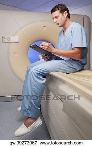 Healthcare worker sitting on a CAT scan machine and writing on a clipboard View Large Photo Image Stock Photo - Healthcare worker sitting on a CAT scan machine and writing on a clipboard. Fotosearch