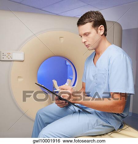 Stock Photograph - Healthcare worker sitting on a CAT scan machine and writing on a clipboard. Fotosearch