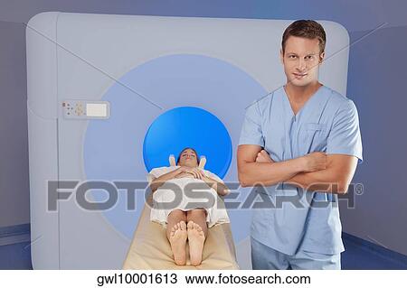 Healthcare worker standing beside a patient undergoing an MRI scan View Large Photo Image Stock Image - Healthcare worker standing beside a patient undergoing an MRI scan. Fotosearch