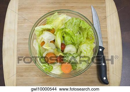 Picture - High angle view of a bowl of salad with a knife. Fotosearch