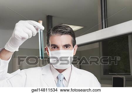 Lab technician analyzing sample in a test tube View Large Photo Image Picture - Lab technician analyzing sample in a test tube. Fotosearch
