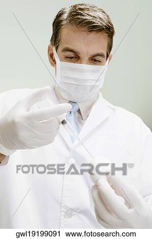 Stock Image - Lab technician injecting into an egg. Fotosearch