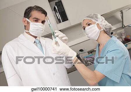 Lab technicians analyzing a sample in a test tube View Large Photo Image Stock Image - Lab technicians analyzing a sample in a test tube. Fotosearch