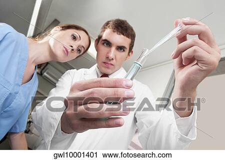 Lab technicians analyzing a sample in a test tube View Large Photo Image Stock Image - Lab technicians analyzing a sample in a test tube. Fotosearch