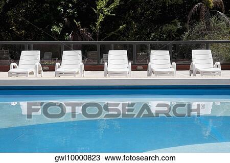 Lounge chairs at the poolside View Large Photo Image Stock Image - Lounge chairs at the poolside. Fotosearch
