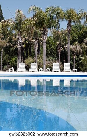 Stock Image - Lounge chairs at the poolside. Fotosearch
