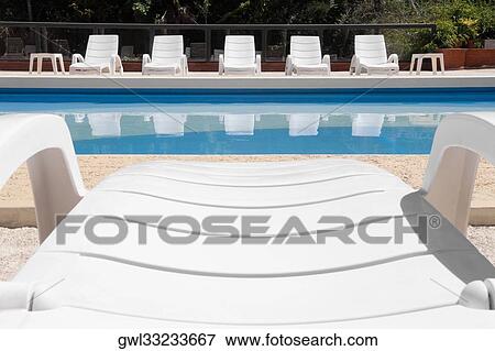 Stock Photo - Lounge chairs at the poolside. Fotosearch