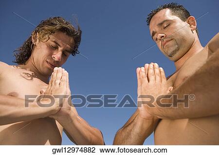 Low angle view of two men meditating View Large Photo Image Stock Image - Low angle view of two men meditating. Fotosearch