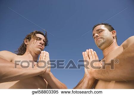 Stock Photography - Low angle view of two men meditating. Fotosearch