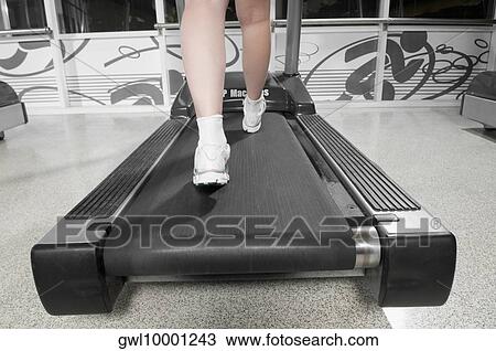 Low section view of a woman walking on a treadmill View Large Photo Image Stock Image - Low section view of a woman walking on a treadmill. Fotosearch