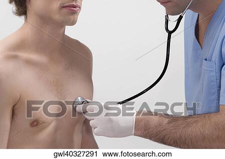 Stock Image - Male doctor examining a patient with a stethoscope. Fotosearch