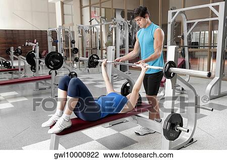 Male instructor assisting a woman in weight training View Large Photo Image Stock Image - Male instructor assisting a woman in weight training. Fotosearch