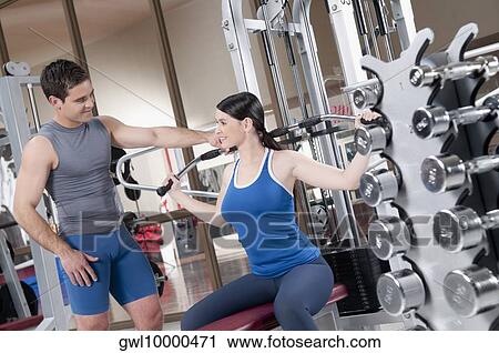 Male instructor helping a woman in exercising View Large Photo Image Stock Image - Male instructor helping a woman in exercising. Fotosearch