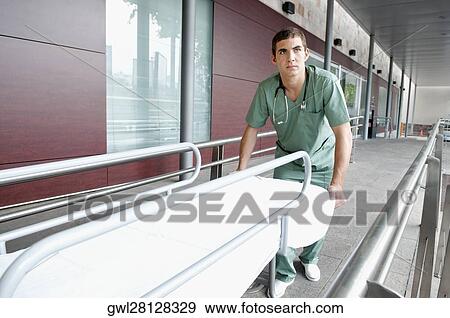 Male nurse pushing a hospital gurney View Large Photo Image Stock Photo - Male nurse pushing a hospital gurney. Fotosearch